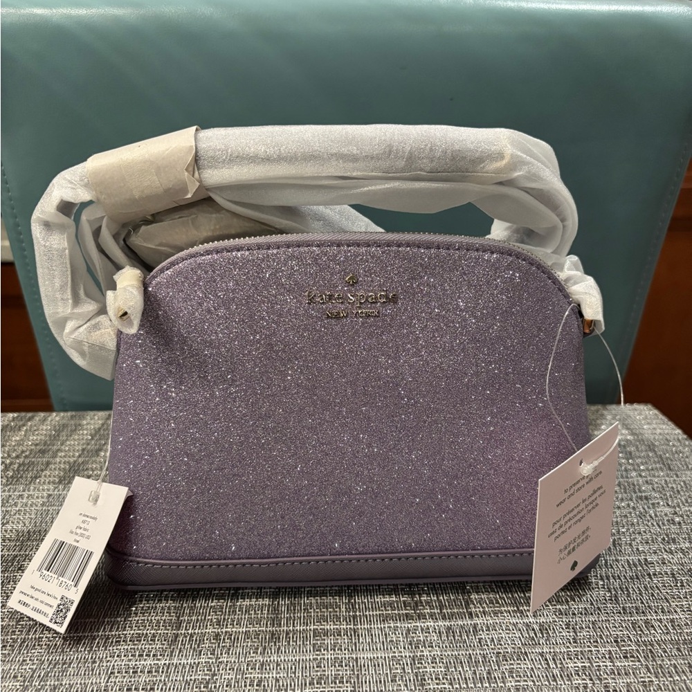 New, original wrapping and tags. Small dome crossbody bag in lilac frost tinsel.